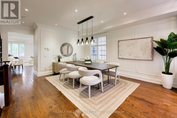 Open-concept living and kitchen area with a large sectional sofa, coffee table, and dining set. - 145b Bannockburn Avenue, Toronto