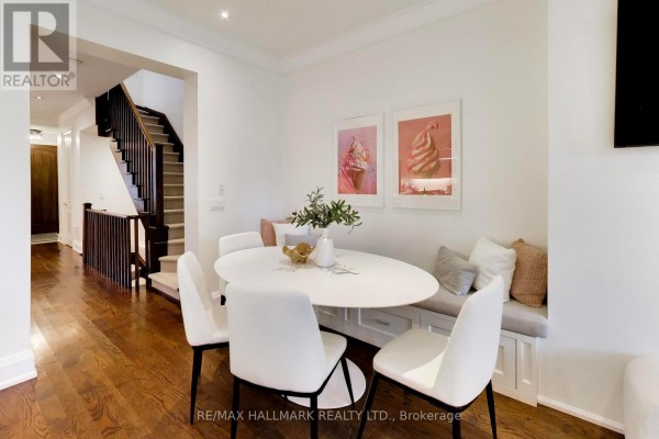 Living room featuring a fireplace, built-in shelving, large TV, sectional sofa, and French doors to the backyard. - 145b Bannockburn Avenue, Toronto