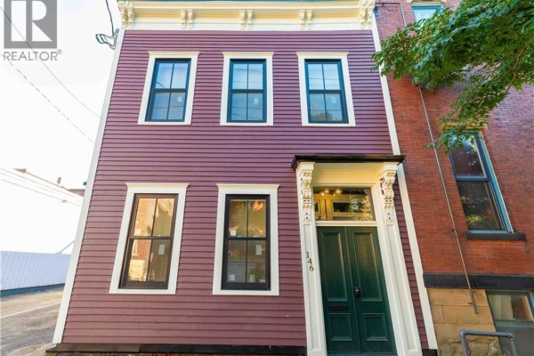 Front exterior of a burgundy apartment building with a dark green double door. - 146 Germain Unit# Apt 2, Saint John