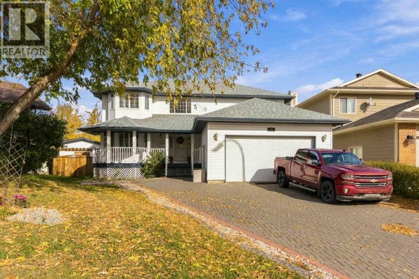 Front exterior of a two-story house with a double garage and seasonal foliage. - 146 Maclaren Crescent, Fort Mcmurray
