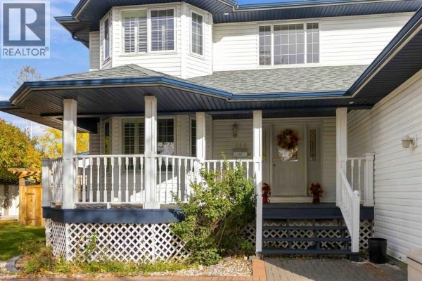 Covered front porch with white railings, white columns, and dark blue lattice skirting. - 146 Maclaren Crescent, Fort Mcmurray