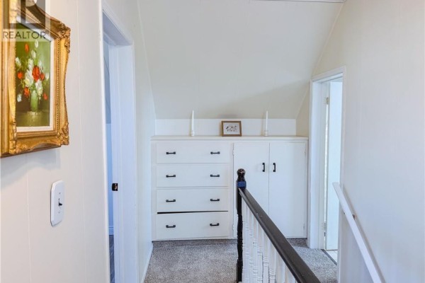 Another angle of the kitchen showing appliances, white cabinets, and a window with a view. - 146 Tripp Settlement Road, Keswick Ridge
