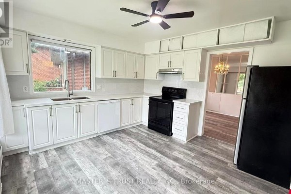 White kitchen with black stove, stainless steel fridge, and ceiling fan. - 146 Yorkview Drive, Toronto