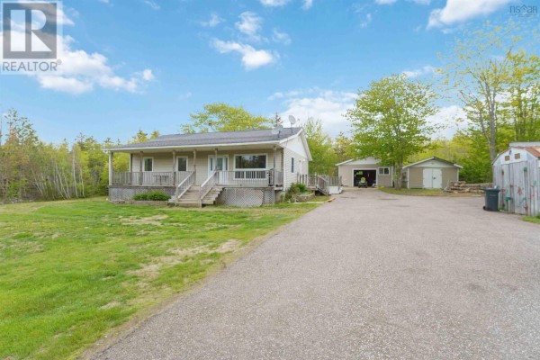 Driveway leads to a beige bungalow with a covered front porch and two outbuildings. - 1460 Hampton Mountain Road, Hampton