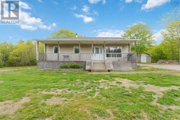 Front view of the beige bungalow from the lawn, showing a covered porch and entrance. - 1460 Hampton Mountain Road, Hampton