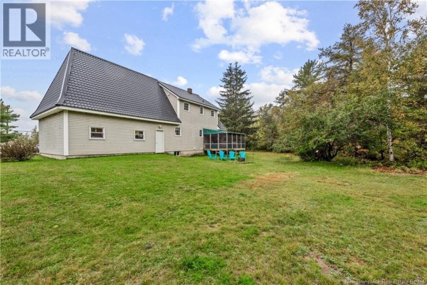 The rear exterior of a light grey house with a dark grey mansard roof and a screened-in porch. - 1460 Saint Charles Nord, Saint Charles