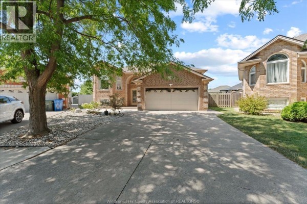 Side view of the house showcasing brickwork, garage, and backyard fence. - 1469 Meridian Street, Windsor