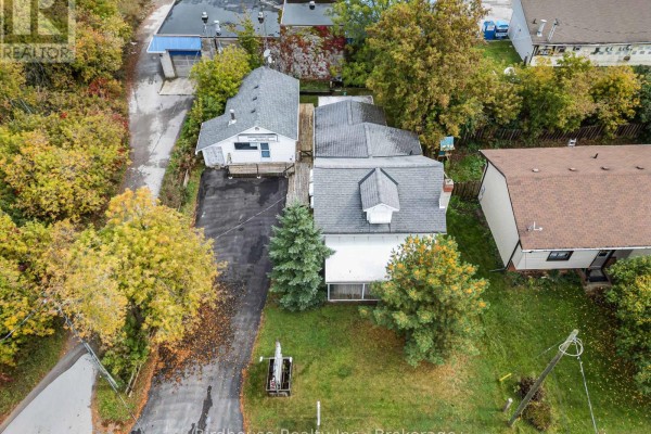 Aerial view of a white house with a grey roof and a separate detached white building on a paved driveway. - 147 East Street N, Kawartha Lakes