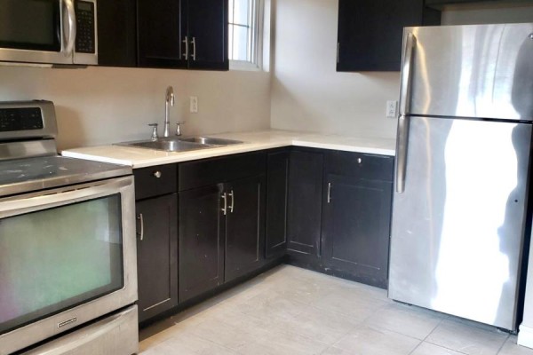 Kitchen with dark wood cabinets, stainless steel appliances, and a double sink. - 147 Holton Avenue S, Hamilton
