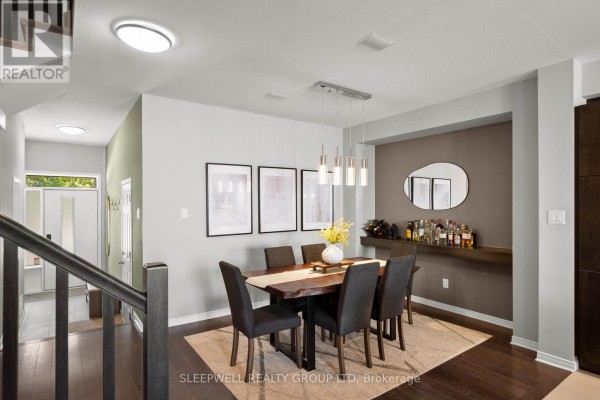 Dining room with dark wood table, six grey chairs, and a wet bar on the right. - 147 Westphalian Avenue, Ottawa