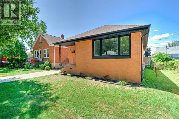 Side exterior view of the brick house showing the driveway and side yard. - 1473 Labadie, Windsor