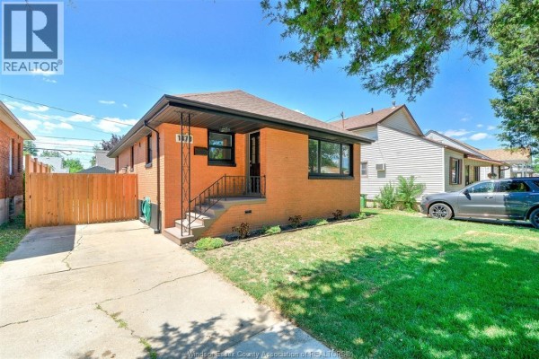 View of the house from the driveway, showing the front entrance and lawn. - 1473 Labadie, Windsor