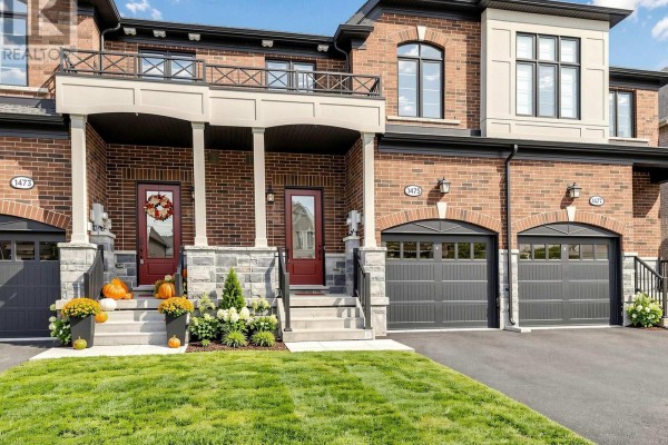 Close-up exterior view of townhouse front doors with decorative pumpkins and fall wreath. - 1475 Blackmore Street, Innisfil