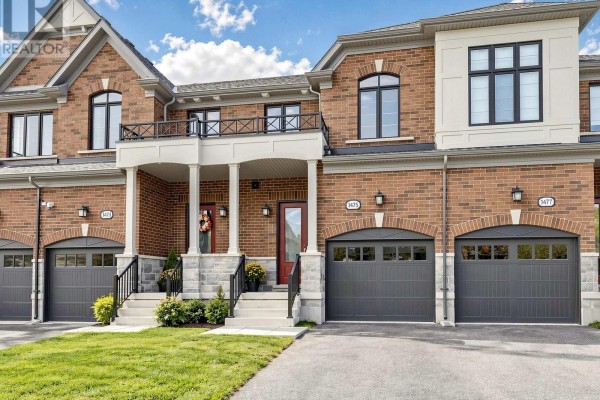 View of brick townhouse exterior showing garages, front entrances and upper balcony. - 1475 Blackmore Street, Innisfil