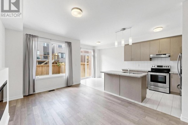 Open concept living area and kitchen with island, stainless steel appliances, and hardwood floors. - 1475 Blackmore Street, Innisfil
