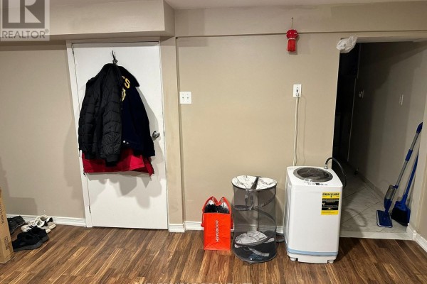 Stainless steel refrigerator next to a stacked washer and dryer unit. - 1476 Cawthra Road, Mississauga