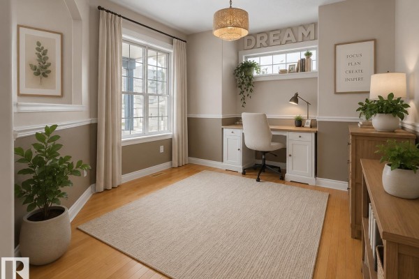 Interior room with light wood floors, a desk and chair, and a large window with hanging plants. - 1476 Mcmillian Wy Sw, Edmonton
