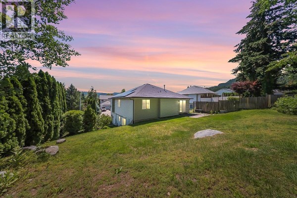 Side view of the house showing the balcony and surrounding greenery. - 1479 37th Street, Castlegar