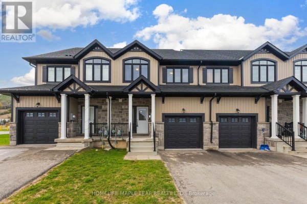 Exterior view of beige and black townhouses with garages and stone accents. - 104 Delphi Court, Blue Mountains