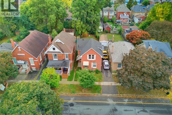 Aerial view of a street with red brick houses and green trees. - 148 Albion Street, Brantford