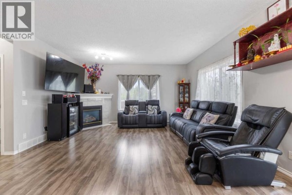 Laundry room with white washing machine, dryer, utility sink, and water heater. - 148 Springmere Way, Chestermere