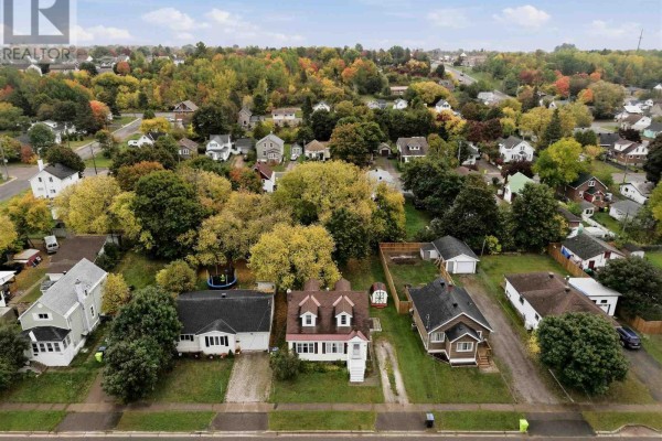 Aerial view of a neighborhood with several houses and trees displaying autumn foliage. - 148 Walnut St, Sault Ste  Marie