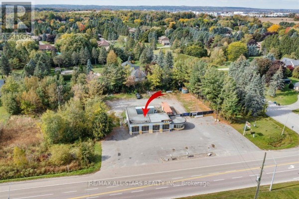 Aerial view of commercial building showing roof details and surrounding wooded area. - 14806 Woodbine Avenue, Whitchurch Stouffville