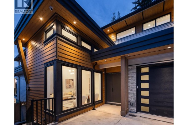 Close-up of the modern house entrance with wood siding and stone detailing. - 1484 Copper Beech Place, Coquitlam