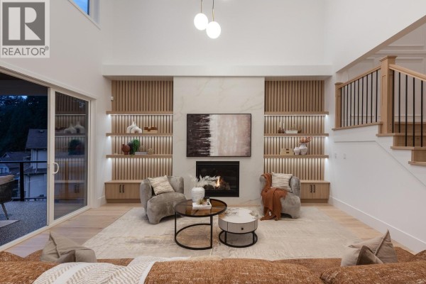 Living room with fireplace, built-in shelving, and large windows. - 1484 Copper Beech Place, Coquitlam