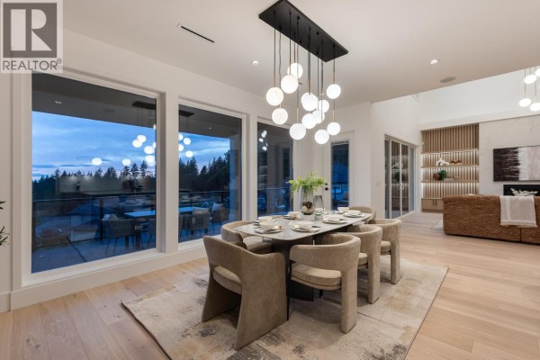 Dining room with a large table, chairs, and a view of the forest. - 1484 Copper Beech Place, Coquitlam