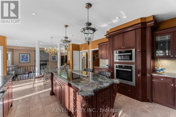 Large kitchen island with granite countertop, built-in ovens and pendant lights - 1486 Ashwood Gate Pickering