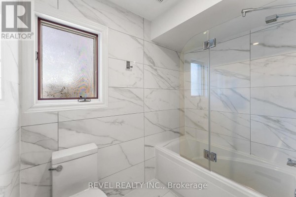 Modern bathroom with marble tiles, tub, and glass screen - 1486 Ashwood Gate Pickering