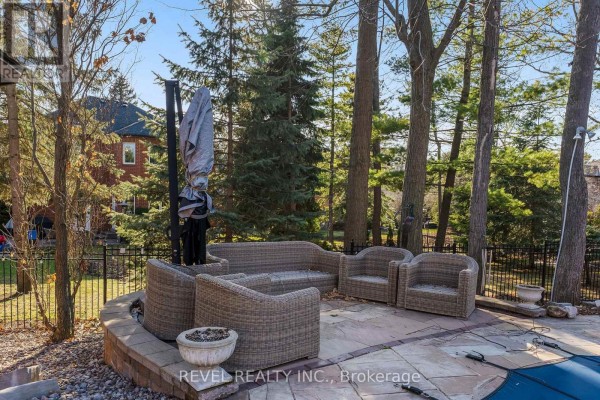 Wicker patio furniture, fire pit, and pool on stone patio with mature trees - 1486 Ashwood Gate Pickering