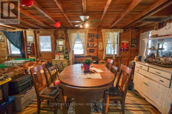 Dining room with wood paneling, oval table, chairs, and vintage dresser - 148b Oak Shores Lane Frontenac