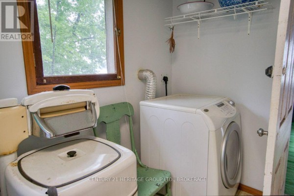 Vintage wringer washer & modern dryer in laundry room with window - 148b Oak Shores Lane Frontenac