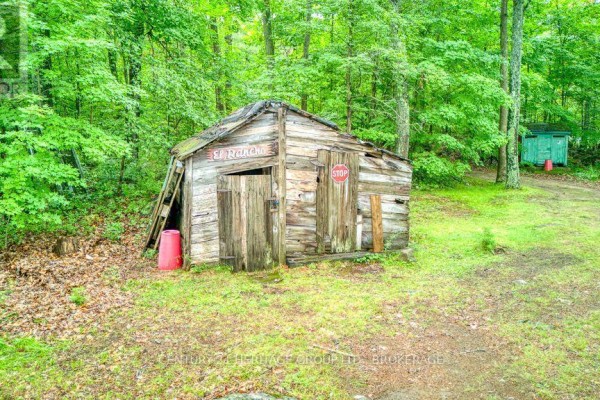 Rustic wooden shed with 'El Rancho' sign and stop sign - 148b Oak Shores Lane Frontenac