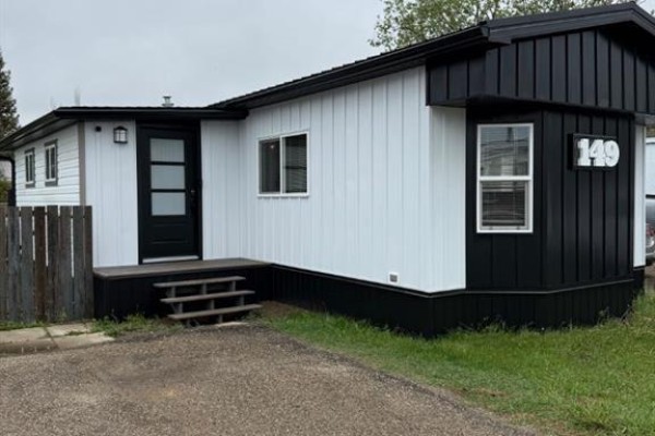 Kitchen with gray cabinets, island with red stools, and view of living room. - 149 Birch Street, Brooks