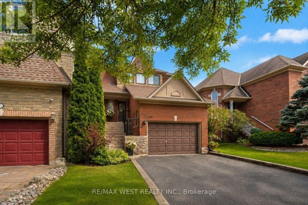 Front exterior of a two-story brick house with a double garage door and stone accents. - 149 Deerglen Terrace, Aurora