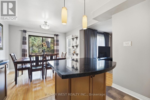 Dining room with granite island, wooden table, and large window - 149 Deerglen Terrace Aurora