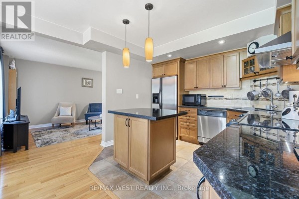 Kitchen with island, granite countertops, stainless steel appliances - 149 Deerglen Terrace Aurora