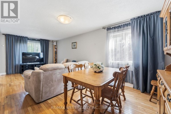 Dining area with a wooden table and chairs, adjacent to a living room with a sofa. - 149 Deerglen Terrace, Aurora