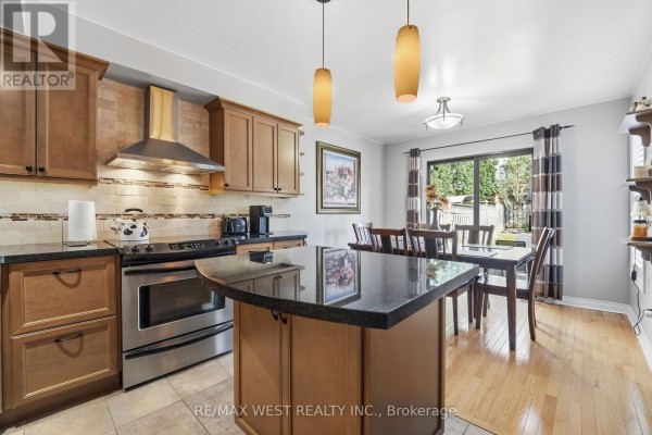 Kitchen island with granite countertop and stainless steel range - 149 Deerglen Terrace Aurora