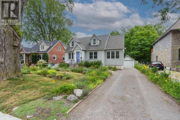 Side view of the house showing a driveway leading to a detached garage. - 149 Dufferin Avenue, Belleville