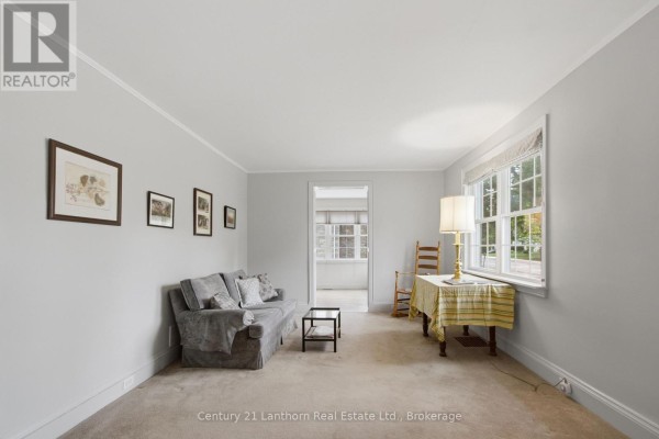 Living room with light grey walls, a grey sofa, and a window overlooking the street. - 149 Dufferin Avenue, Belleville