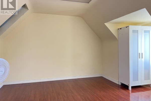 Attic room with sloped walls, hardwood floor, and a white storage cabinet. - 149 Finch Avenue W, Toronto
