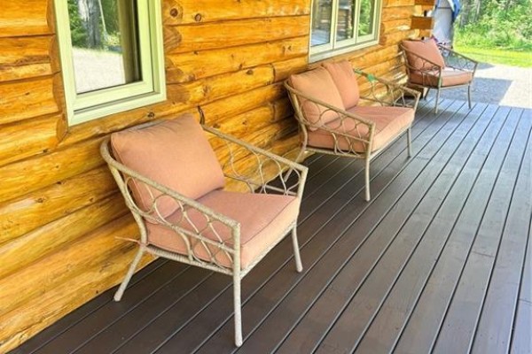 Close-up of wicker chairs with coral cushions on a dark wooden porch. - 149 Maclean Crossroad Road, Irishtown