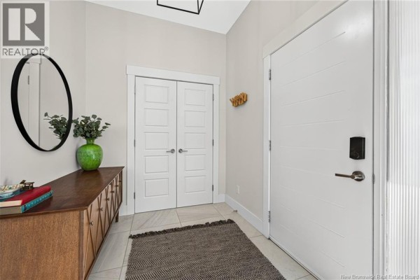 Rear view of a modern grey two-storey house with a covered deck and screened-in porch. - 149 Oakfield Drive, Riverview