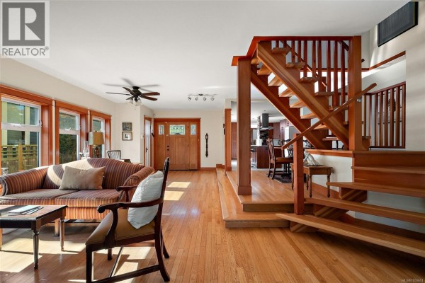 Living room featuring a staircase, dining area, and view towards the entryway. - 149 St. Lawrence St, Victoria