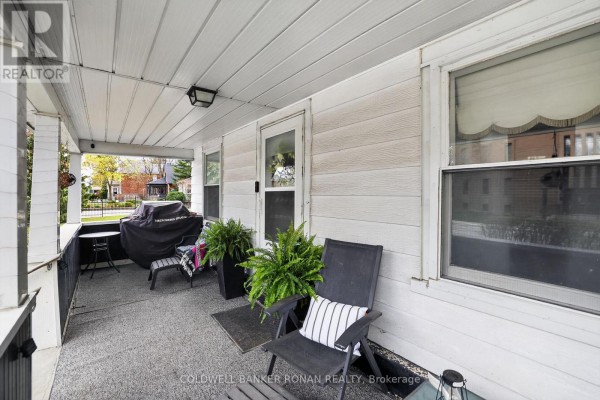 Covered porch with seating, a grill, and ferns on a grey textured floor. - 149 Victoria Street W, New Tecumseth