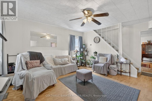 Living room with neutral-colored furniture, a ceiling fan, and a staircase. - 149 Victoria Street W, New Tecumseth